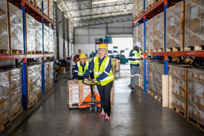Warehouse workers with uniform working in distribution warehouse.